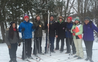 students standing with skis outside in the snow