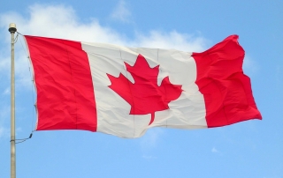 Canada flag waving against blue sky