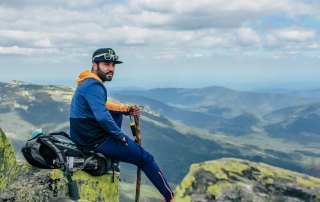 male climber sitting atop the Carpathian Mountains, Ukraine
