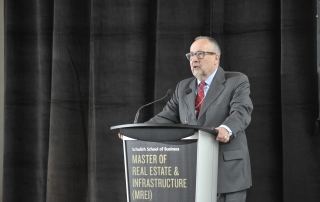 Professor Andre Kuzmicki speaking at a podium