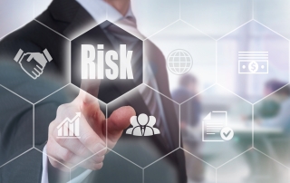 Businessman pressing a hollographic risk concept button.