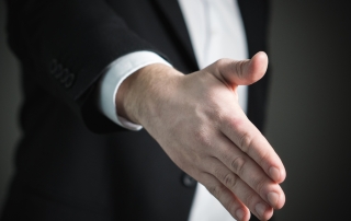 man in a suit reaching out for a handshake