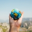 outstretched hand holding a small globe